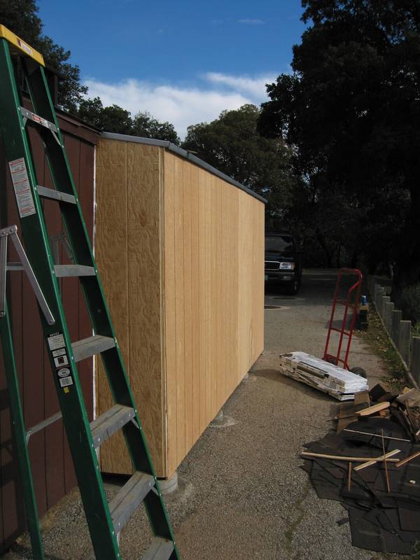 Siding on the main side. Old shed shingles in a pile on the right; new ones just behind.